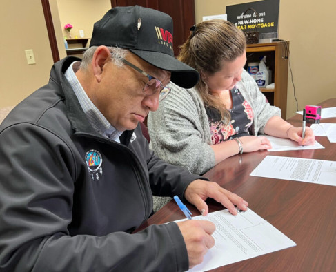 At a land title office in Sycamore, IL, Prairie Band Potawatomi Chairman Joseph Rupnick signs document transferring 130 acres of tribal-owned land in DeKalb County to the federal government, for use as reservation land.