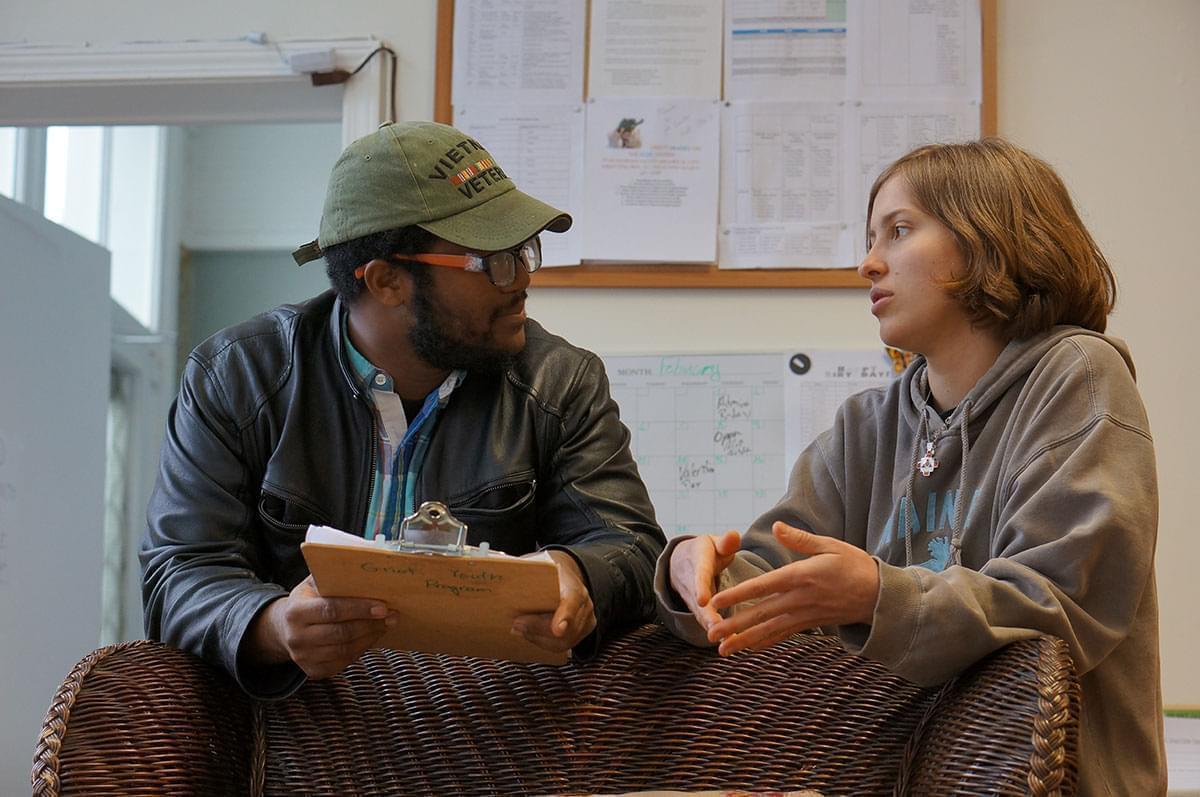 Stella Faux talking with a man holding a clipboard