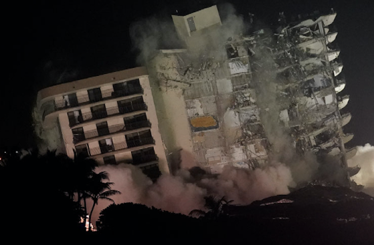 The damaged remaining structure at the Champlain Towers South condo building collapses in a controlled demolition, Sunday, July 4, 2021, in Surfside, Fla. The decision to demolish the Surfside building came after concerns mounted that the damaged structure was at risk of falling, endangering the crews below and preventing them from operating in some areas.