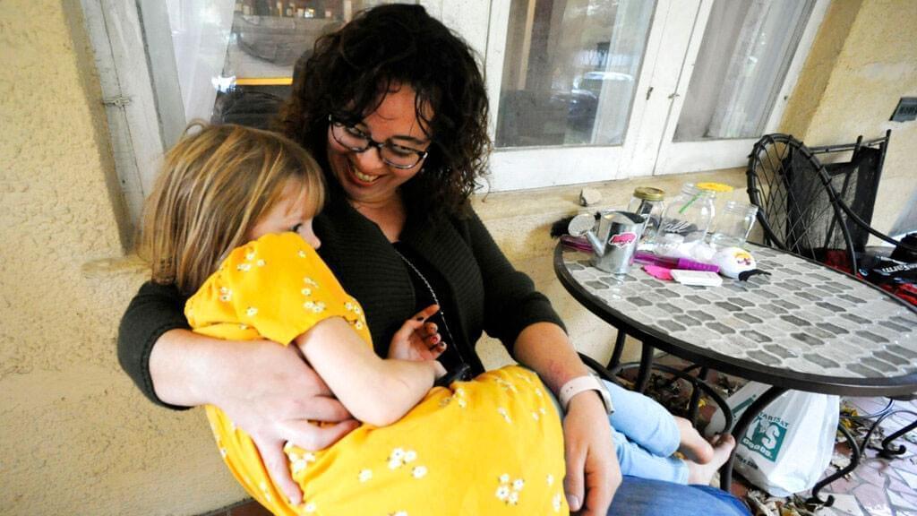 Sarah Clemente snuggles with daughter Penelope Clemente, 6, at their home in Charleston, W.Va., on Saturday, Oct. 30, 2021. Clemente supported a paid family medical leave proposal that was removed from President Joe Biden's social spending plan because of opposition from West Virginia Sen. Joe Manchin.