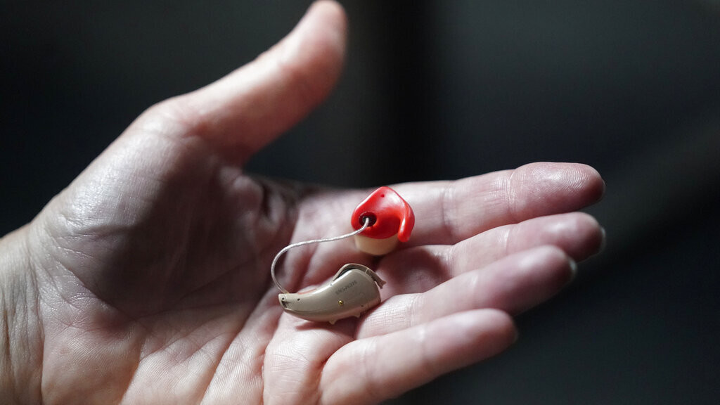 Chelle Wyatt holds her hearing aid Friday, April 15, 2022, in Salt Lake City. People with hearing loss have adopted technology to navigate the world, especially as hearing aids are expensive and inaccessible to many. 