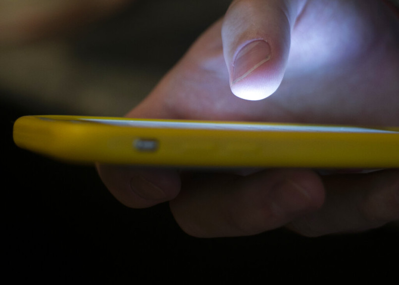 In this Sunday, Aug. 11, 2019, photo, a man uses a cell phone in New Orleans. Quick help for suicidal thoughts and other mental health emergencies may soon be as easy as 9-8-8. The United States’ first nationwide three-digit mental health crisis hotline goes live on Saturday, July 16, 2022.