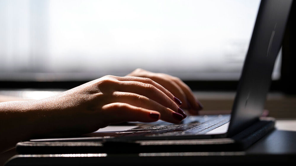 A woman types on a laptop while on a train in New Jersey. After about a trial of the four-day workweek in the United Kingdom found that the schedule reduced stress and maintained their productivity, 92% of the companies that participated said they would continue with the reduced work hours.