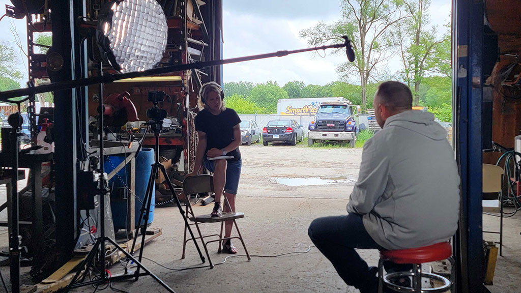 woman interviews man in garage