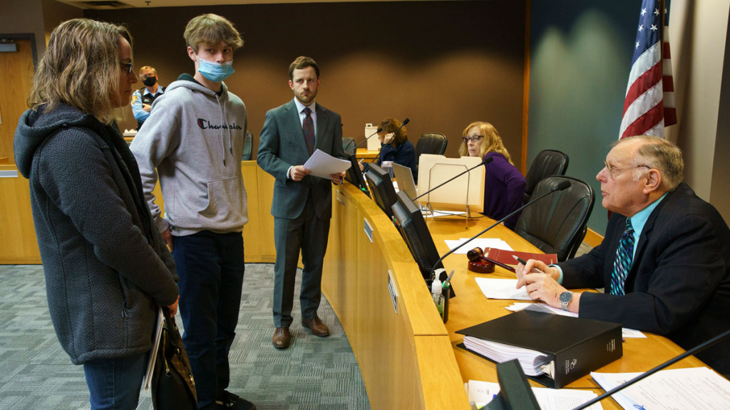 Michele Nepras and her son Nathan, 16, talk with McHenry city prosecutor Michael Fioretti, center, and adjudication hearing officer Harry H. Semrow Jr. in March. Nathan had received a ticket for disorderly conduct related to a fight on a school bus.