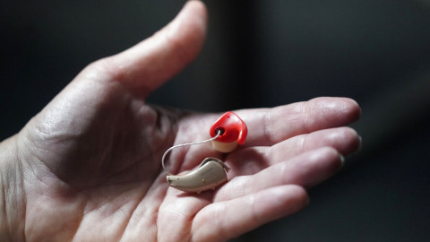 Chelle Wyatt holds her hearing aid Friday, April 15, 2022, in Salt Lake City. People with hearing loss have adopted technology to navigate the world, especially as hearing aids are expensive and inaccessible to many. 